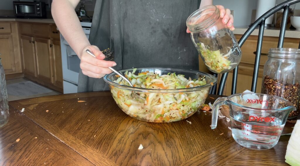 putting kimchi into a mason jar