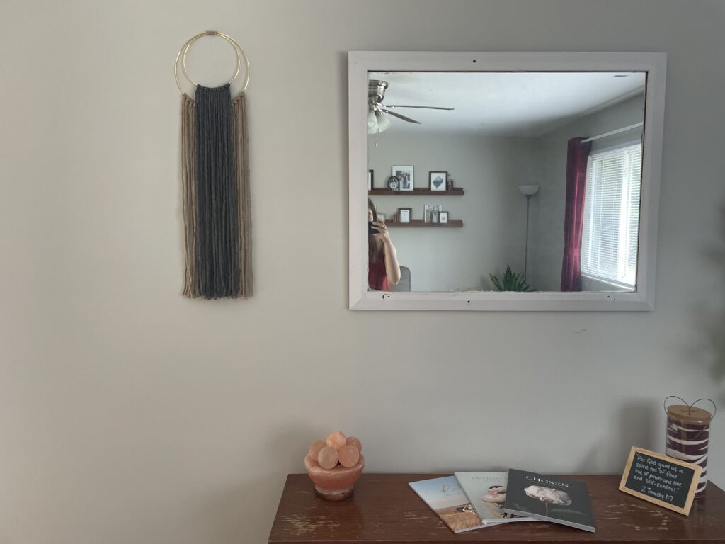 macrame wall hanging and other decor with mirror and table