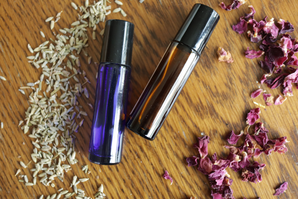 essential oil roller bottles with lavender and rose petals
